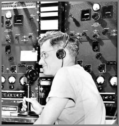 Al Klopp at the WAS mic in the 1950s. Receivers and other gear behind him.