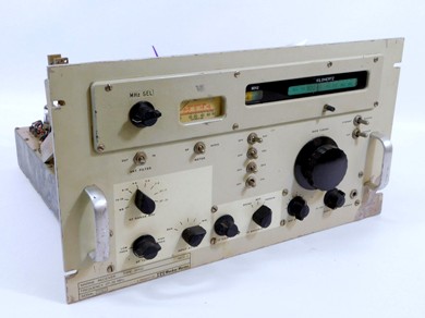 Rack-mount 1960s? receiver with a light gray front, slide-rule dial, meter and 8 knobs 
