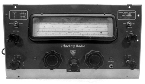 Gray tabletop receiver with large slide-rule dial and 7 knobs