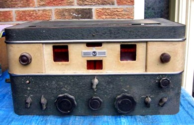 Table-top receiver with 2 large tuning knobs, 4 medium size knobs,  5 small knobs and 3 dial/meter windows