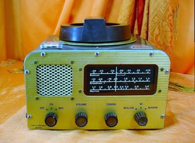 Front/top view of RMCA radio--direction-finding receiver with compact loop and null meter on top, 3 band slide-rule dial, 4 knobs and small speaker