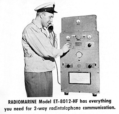 Man holding a handset and operating a 4 foot high transceiver with 3 meters, 4 knobs, a hangup loop for the handset and a speaker